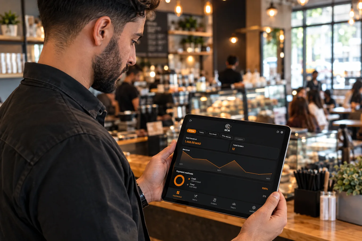 Café owner reviewing the GCR revenue dashboard on a tablet